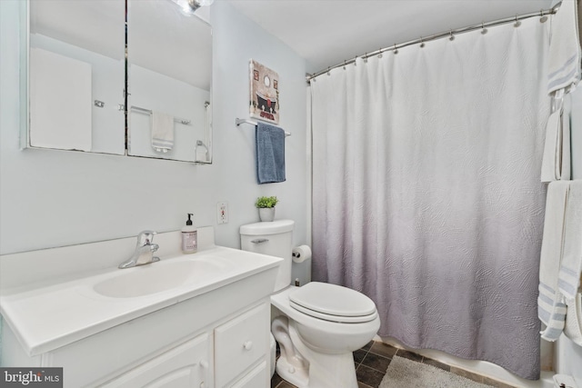 bathroom with toilet, vanity, and walk in shower