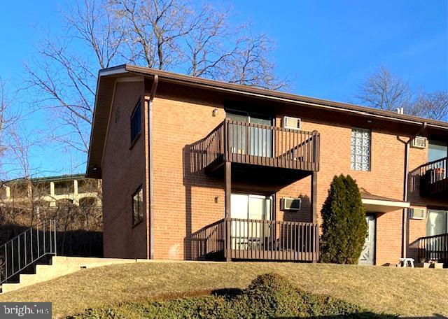 back of house featuring a balcony and a yard