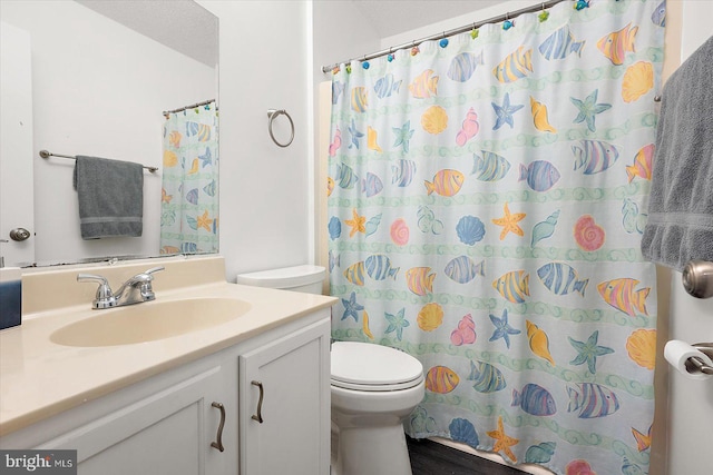 bathroom with walk in shower, vanity, and toilet