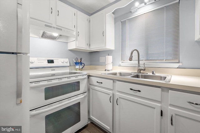 kitchen with white appliances, sink, and white cabinets