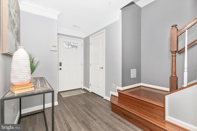 entrance foyer with stairs, baseboards, wood finished floors, and crown molding