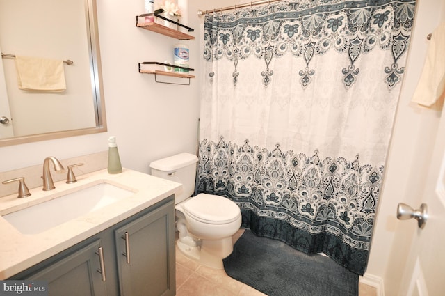 bathroom featuring vanity, tile patterned flooring, toilet, and walk in shower