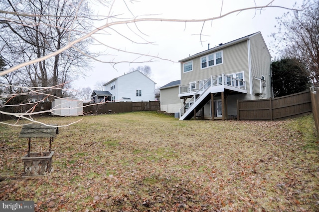 back of property featuring a storage shed, a deck, and a lawn