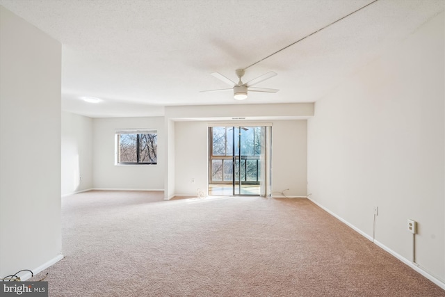 carpeted spare room with a textured ceiling and ceiling fan