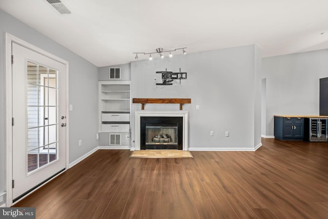 unfurnished living room with dark hardwood / wood-style flooring, beverage cooler, and built in features