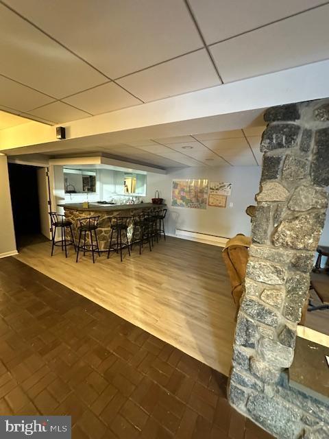 dining room featuring bar area, a paneled ceiling, and baseboard heating