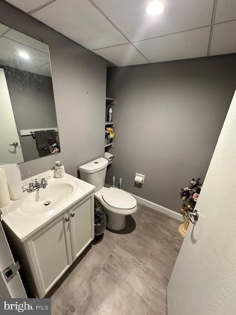 bathroom with vanity, a paneled ceiling, and toilet