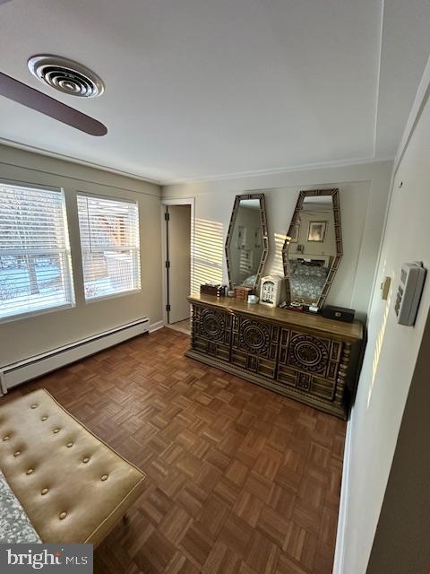 hallway featuring a baseboard radiator and dark parquet flooring