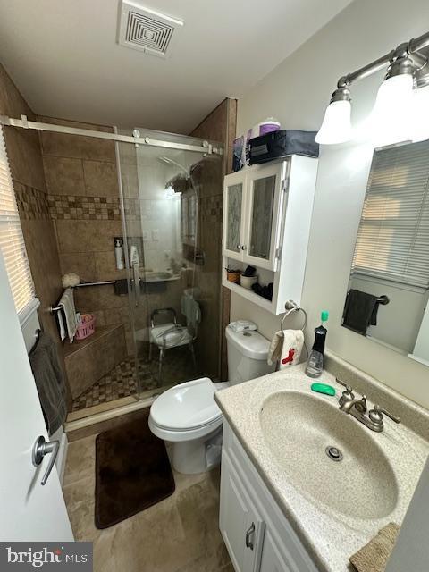 bathroom with vanity, an enclosed shower, and toilet