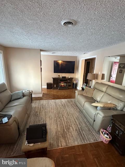 living room featuring parquet floors and a textured ceiling