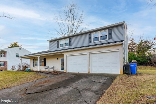 front facade with a garage, a front yard, and covered porch