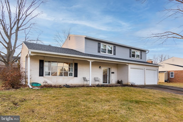 view of property featuring a garage, covered porch, and a front yard