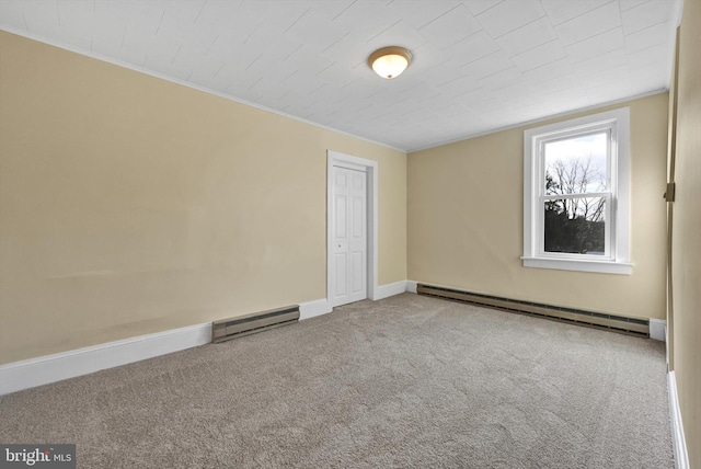 carpeted spare room featuring baseboard heating