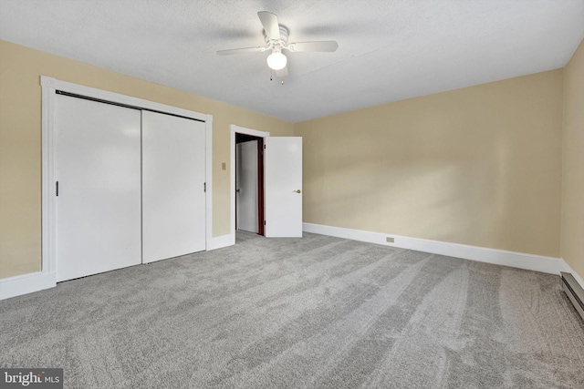 unfurnished bedroom with a textured ceiling, carpet floors, a closet, and ceiling fan