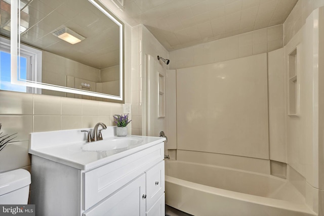 full bathroom featuring toilet,  shower combination, tile walls, vanity, and backsplash