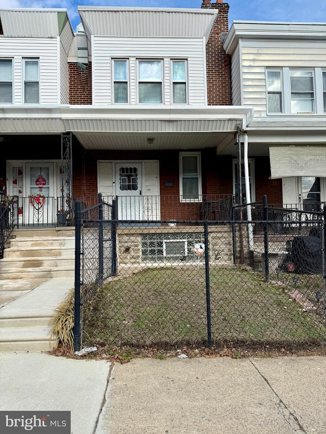 multi unit property with covered porch and a front lawn