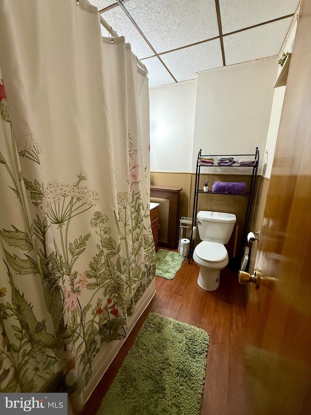 bathroom featuring a paneled ceiling, hardwood / wood-style floors, and toilet