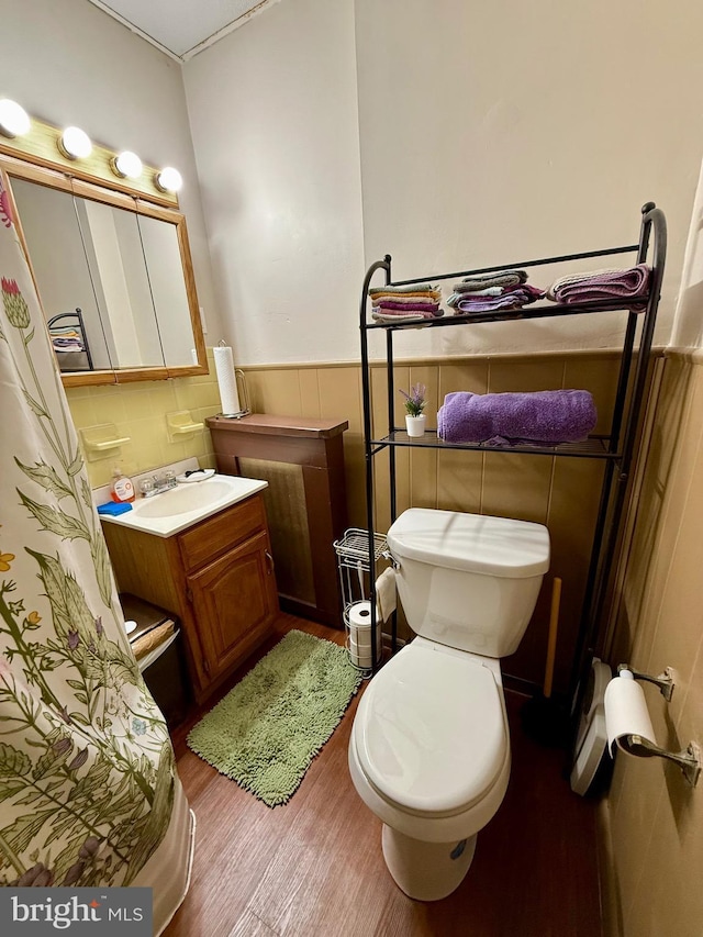 bathroom featuring vanity, wood-type flooring, tile walls, and toilet