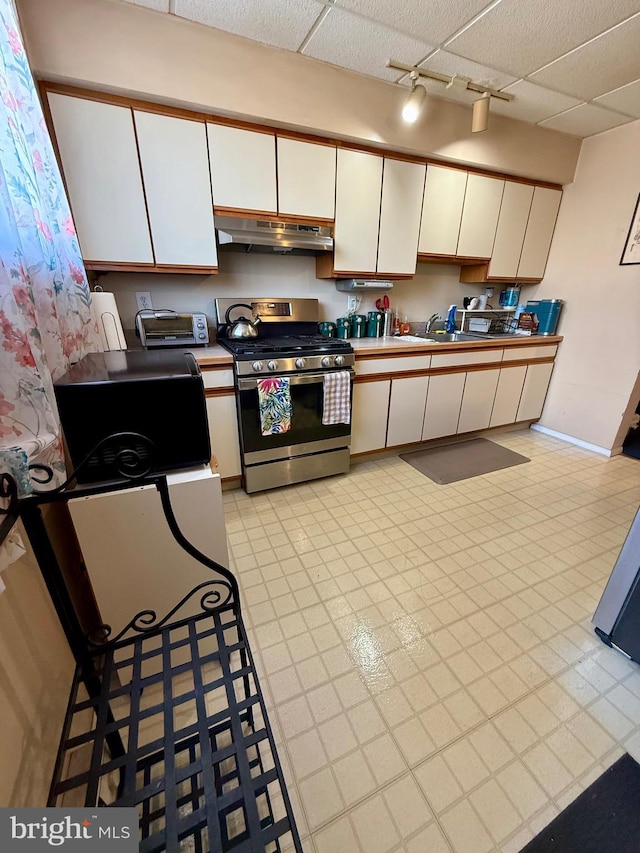 kitchen featuring white cabinetry, track lighting, sink, and gas stove