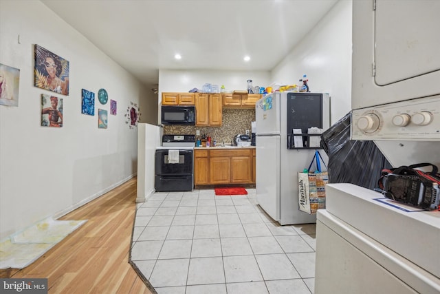 kitchen featuring light tile patterned floors, decorative backsplash, and black appliances