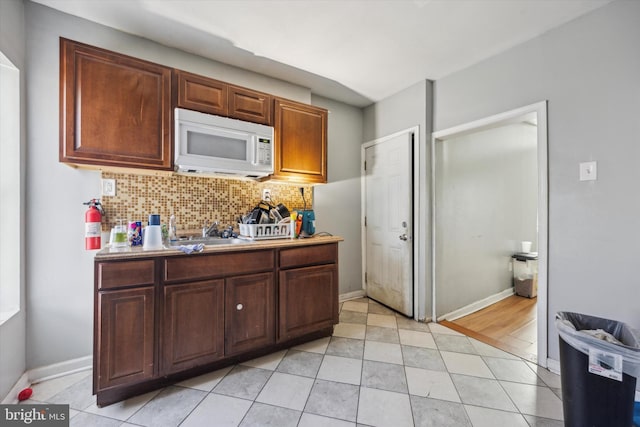 kitchen featuring sink, light tile patterned floors, and backsplash