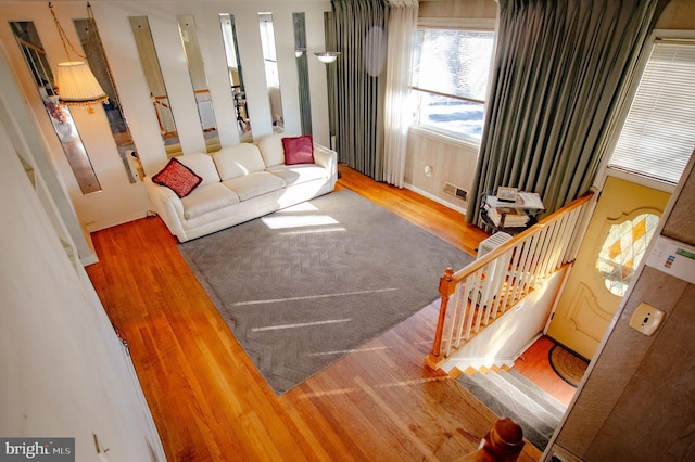 living room with visible vents, stairway, and wood finished floors