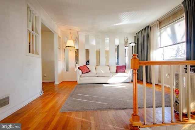 unfurnished room featuring wood-type flooring, visible vents, and baseboards