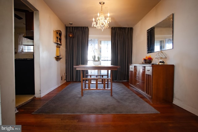 dining area featuring baseboards, an inviting chandelier, and wood finished floors