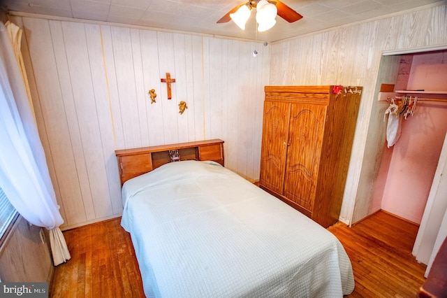 bedroom featuring ceiling fan, a closet, and wood finished floors