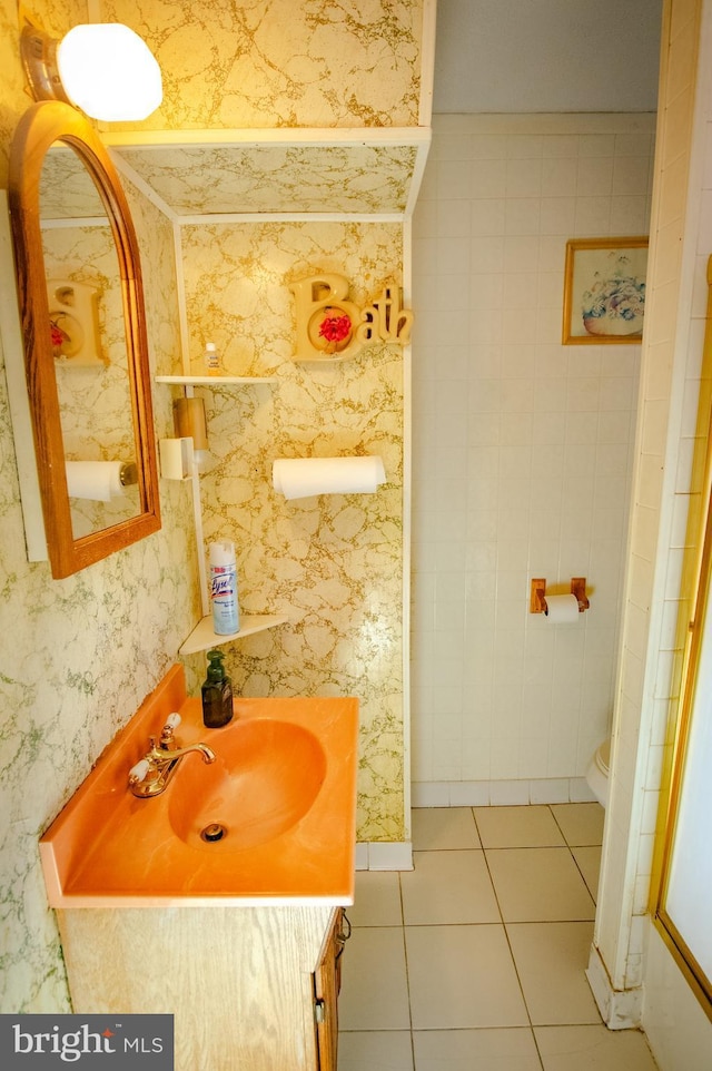 bathroom with a shower, tile patterned floors, vanity, and wallpapered walls