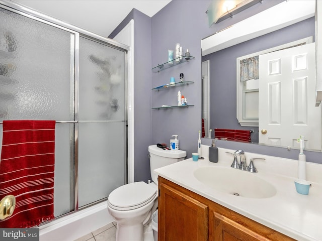 bathroom with tile patterned flooring, an enclosed shower, vanity, and toilet