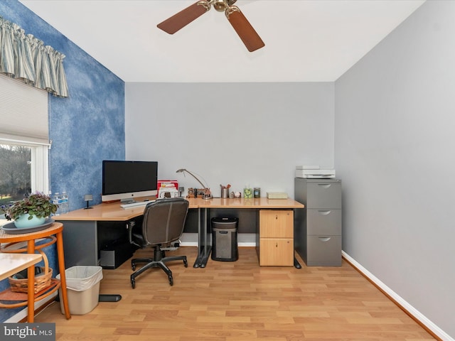 home office with light hardwood / wood-style flooring and ceiling fan