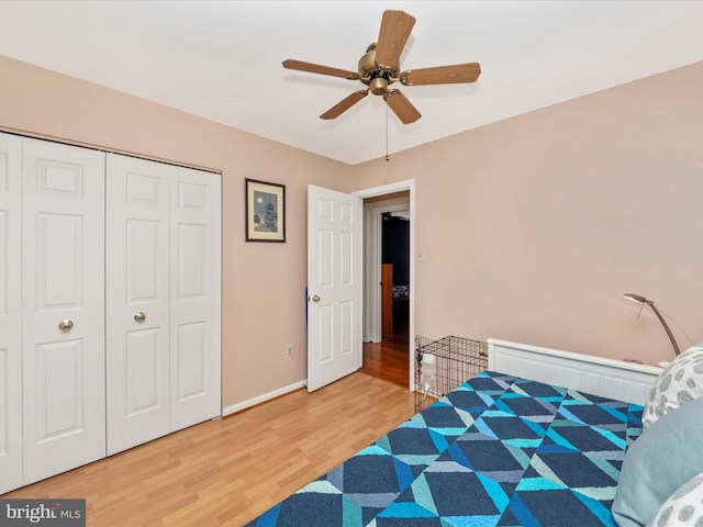 bedroom with wood-type flooring, ceiling fan, and a closet