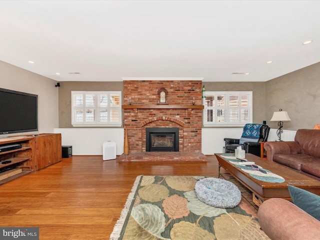 living room with wood-type flooring and a fireplace