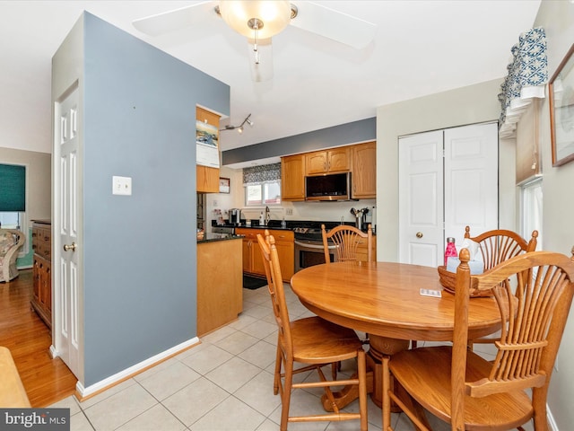 tiled dining room with sink and ceiling fan