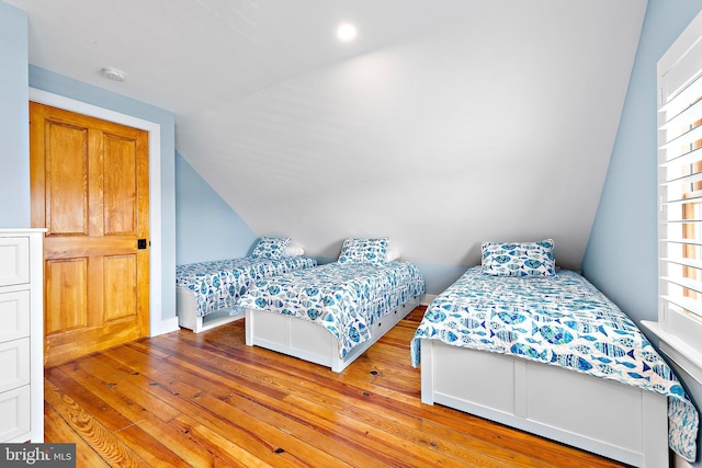 bedroom with lofted ceiling and light hardwood / wood-style floors