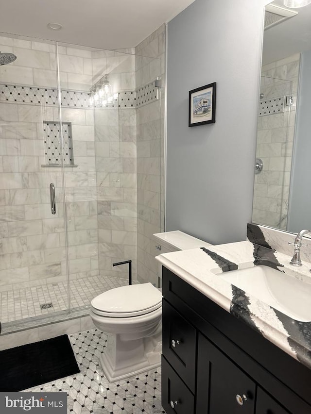 bathroom featuring vanity, toilet, and a shower with door