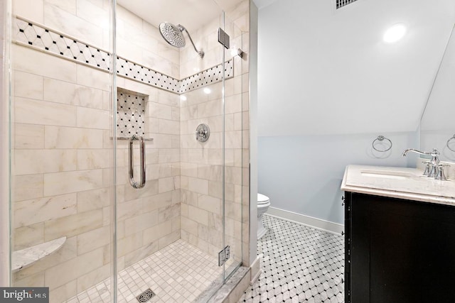 bathroom featuring vanity, vaulted ceiling, a shower with door, and toilet