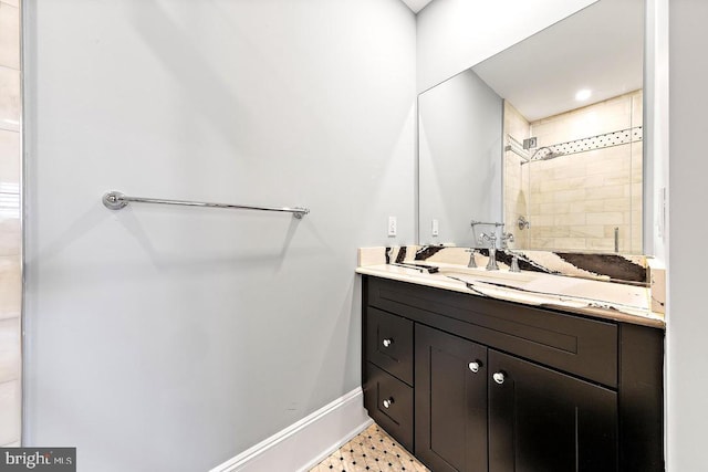 bathroom with tiled shower and vanity