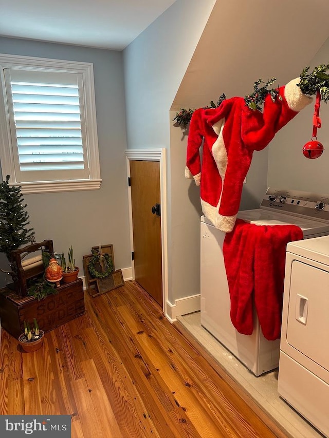 laundry room with wood-type flooring and washer and dryer