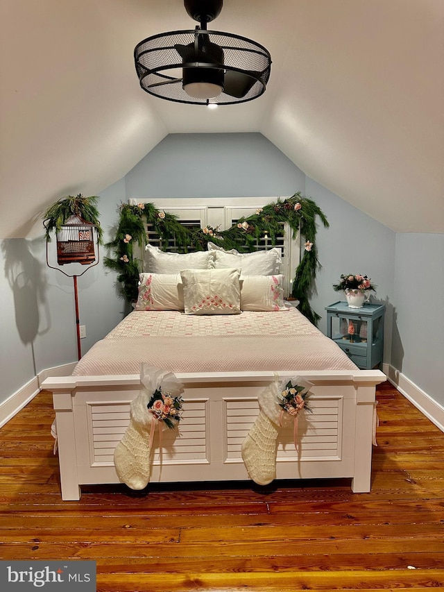 bedroom with lofted ceiling and dark hardwood / wood-style flooring