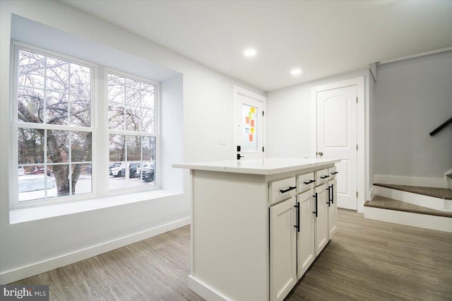 bar with white cabinetry and light hardwood / wood-style floors