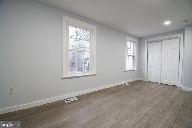 unfurnished bedroom featuring hardwood / wood-style flooring and a closet