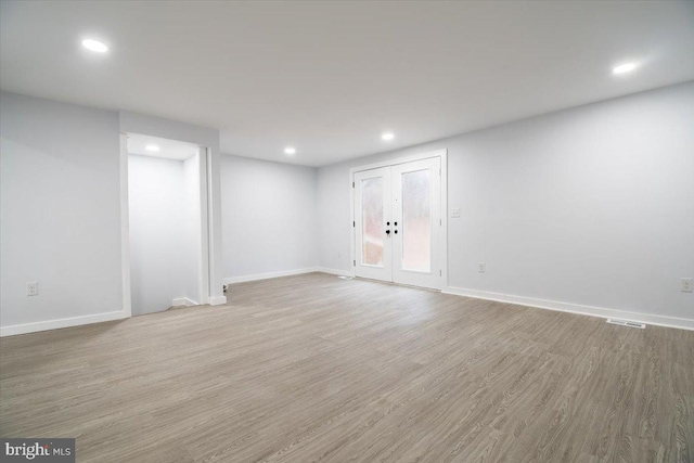 empty room featuring light wood-type flooring and french doors