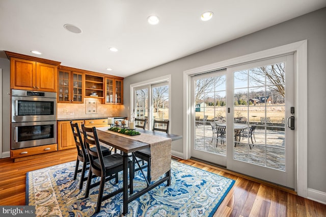 dining space featuring baseboards, wood finished floors, and recessed lighting