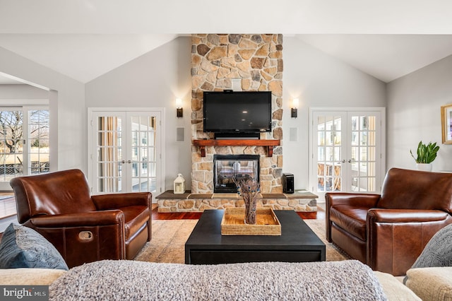 living area with lofted ceiling, french doors, a fireplace, and light wood finished floors