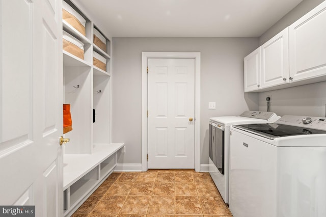 laundry area featuring cabinet space, light tile patterned floors, baseboards, and washer and clothes dryer