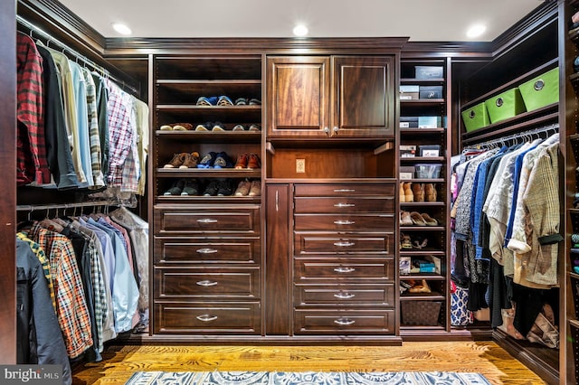 walk in closet with light wood-style flooring