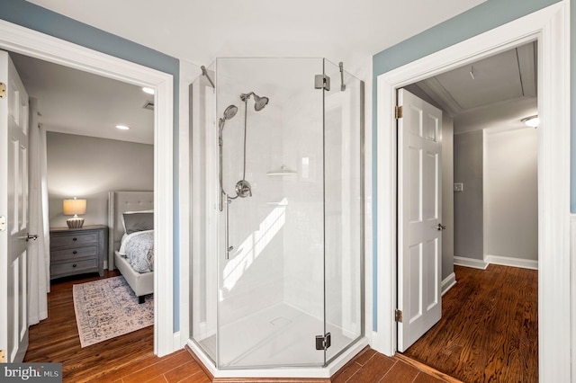 full bathroom with a stall shower, baseboards, ensuite bath, and wood finished floors