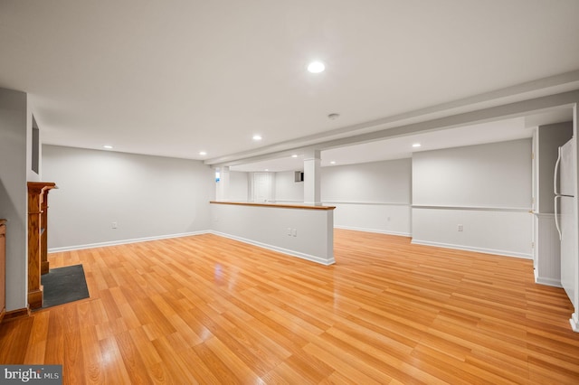 finished basement featuring light wood-type flooring, baseboards, and recessed lighting